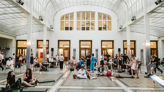 Die Kassenhalle der Postsparkasse am Georg-Coch-Platz mit stehenden und sitzenden Menschen