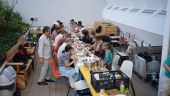 Foto einer Gruppe von Menschen an einem langen Tisch gefüllt mit Essen.