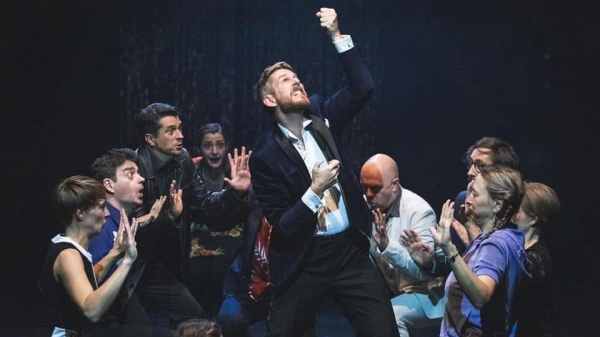 Performer Jim Libby auf einer Bühne mit anderen Schauspielern